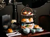 Afternoon Tea in Biggar - Three tier cake stand with Scones, cakes, sandwiches, tea and coffee on a wooden table.